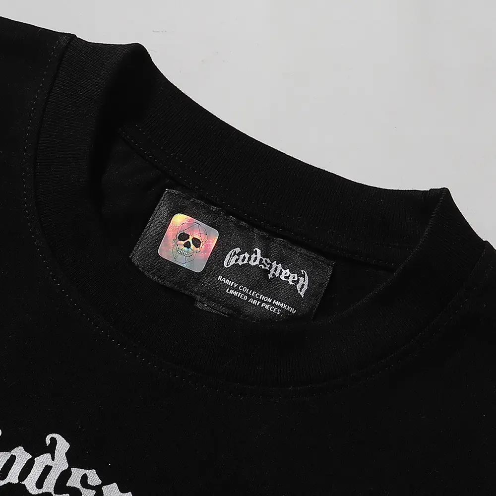 Detailed close-up of the tee's neck label, featuring wash care instructions and subtle brand branding in a clean, minimalist typography