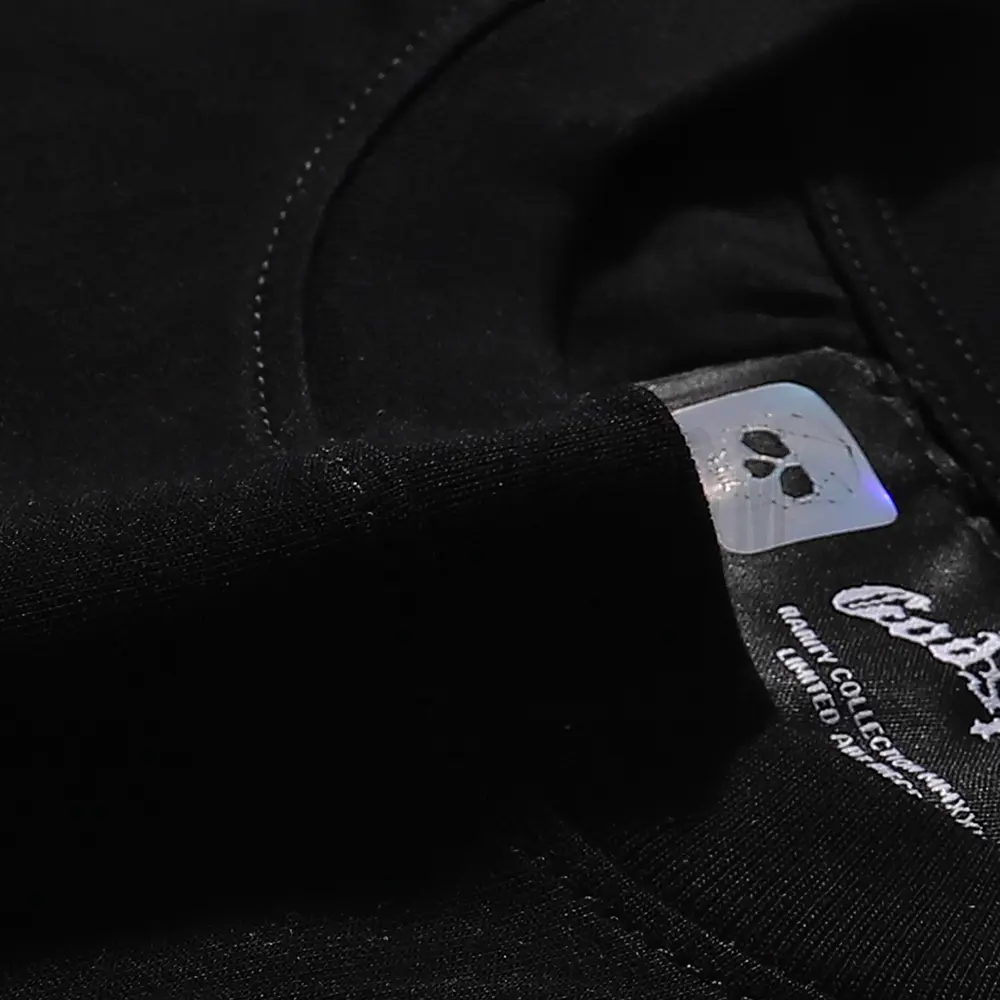 Detailed close-up of the tee's neck label, featuring wash care instructions and subtle brand branding in a clean, minimalist typography