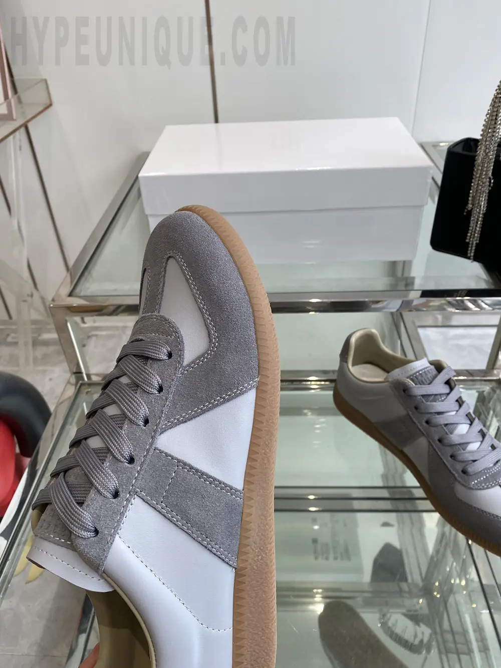 a pair of beige shoes on a glass shelf