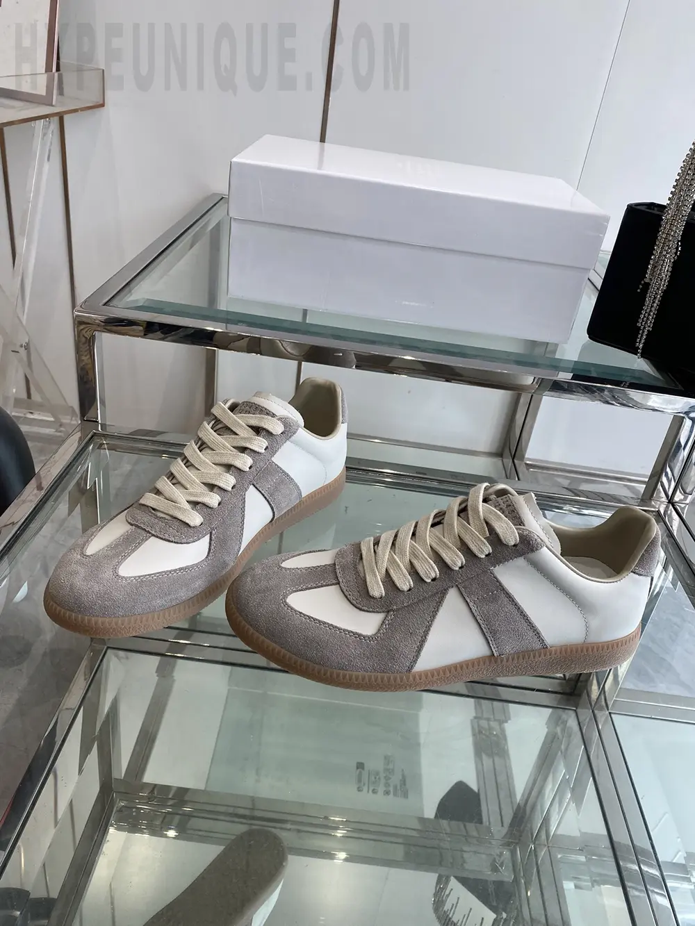 a pair of beige shoes on a glass shelf