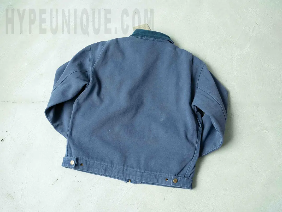 Carhartt X Stussy J97 Jacket blue back view. Mainly showing the overall blue simple design of the back