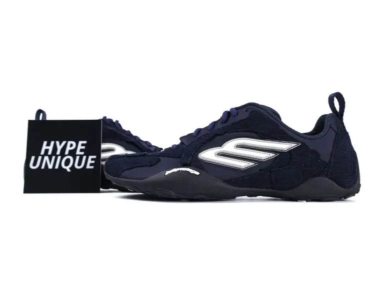 Dark blue sneakers with fabric upper, silver logo, and black rubber sole.