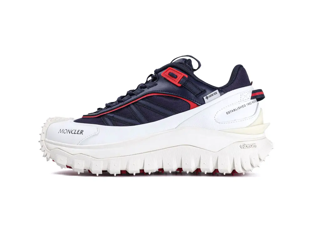 Navy and white sneaker with red accents, featuring Gore-Tex material and chunky rubber sole.