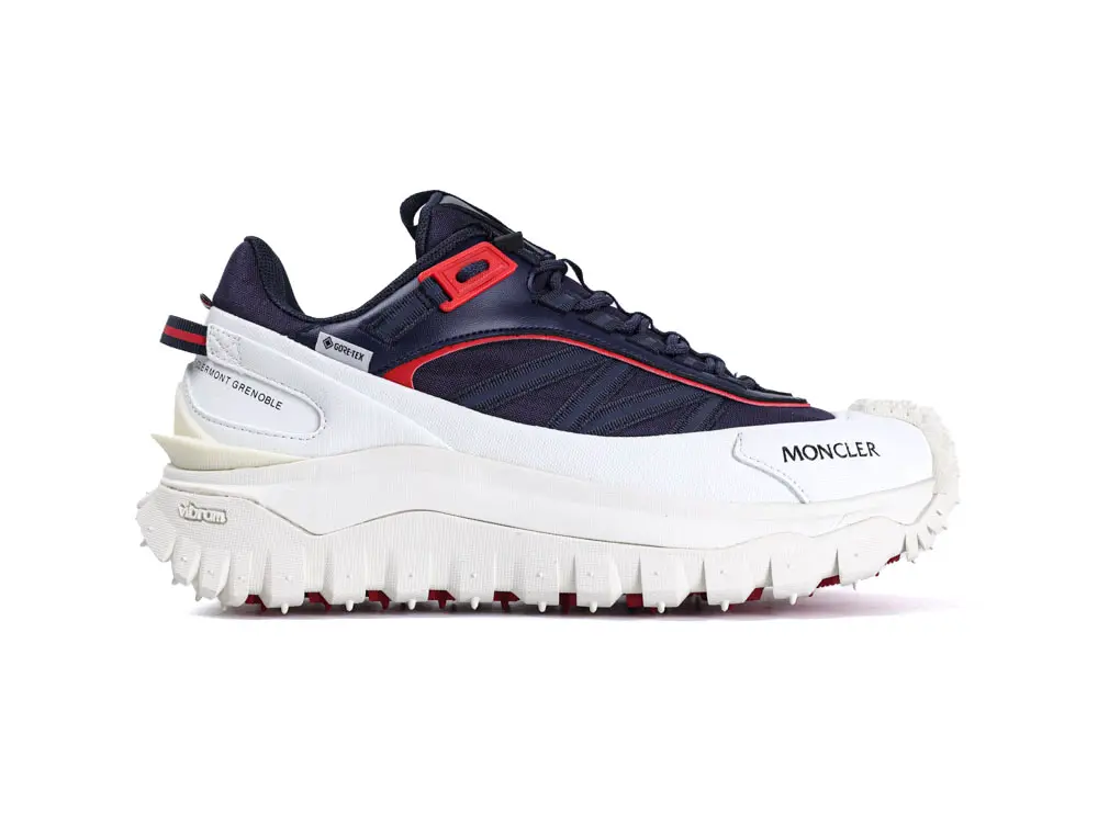 Navy and white sneaker with red accents, textile upper, and thick rubber sole.