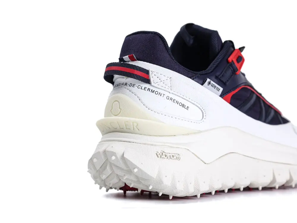 Navy and white sneaker with red accents, rubber sole, and textile upper.