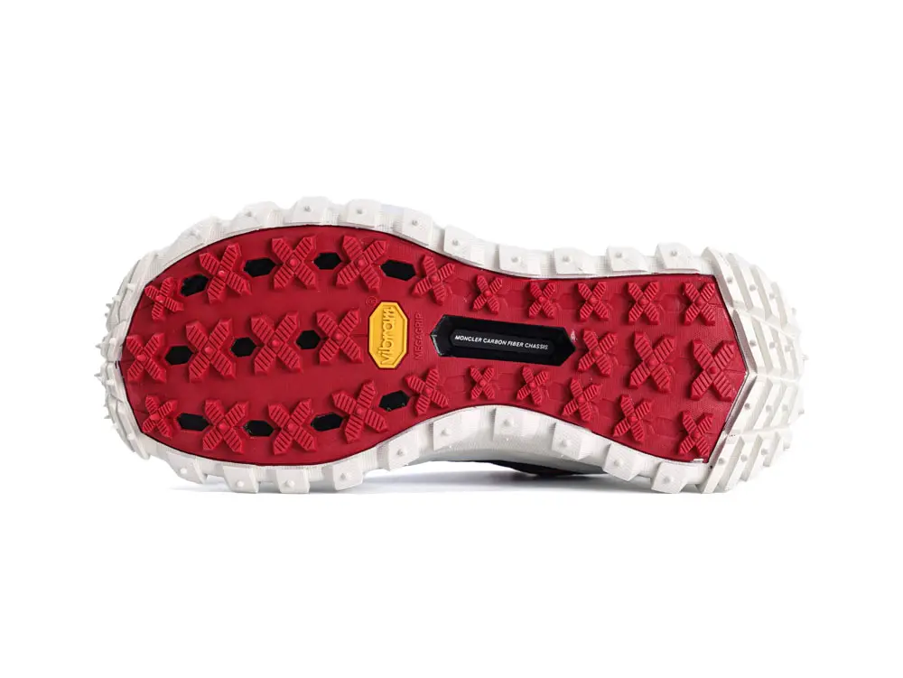Red and white rubber shoe sole with textured grip and carbon fiber detail.