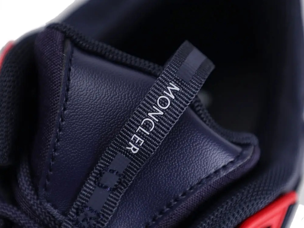 Naval blue leather sneaker tongue with black fabric pull tab featuring text.