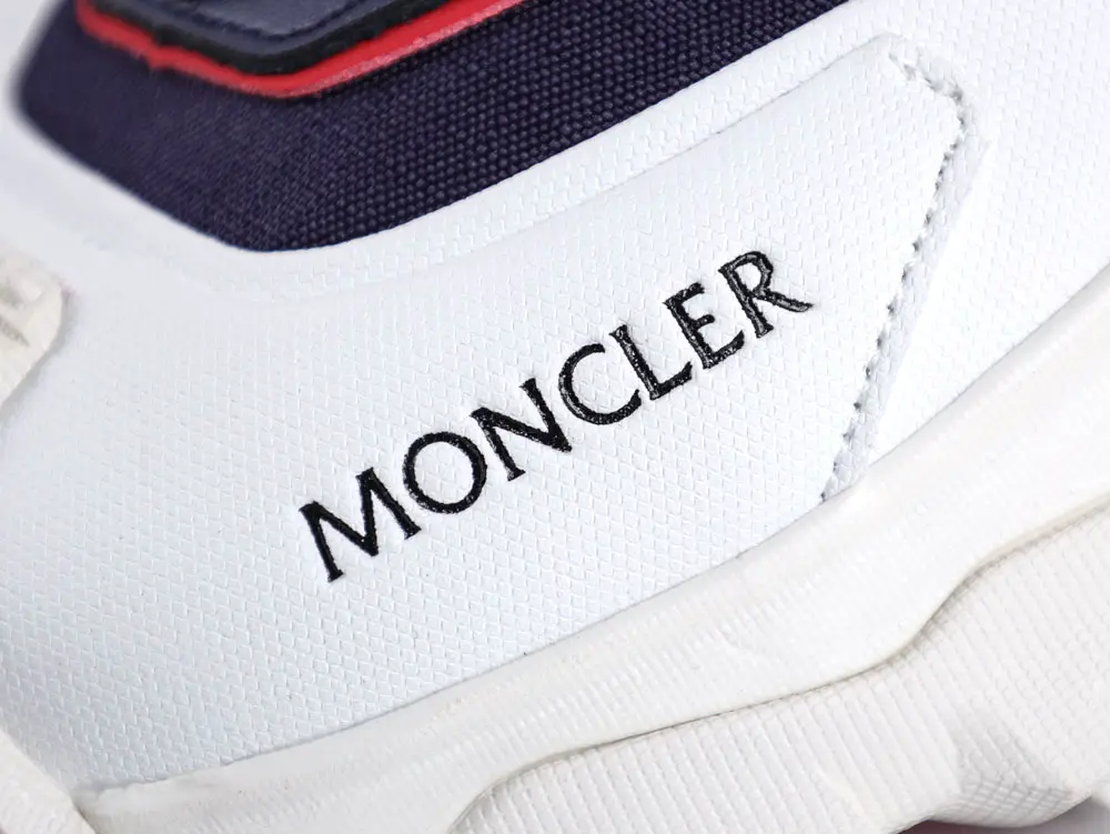 White textured sneaker with navy and red accents, featuring brand logo.