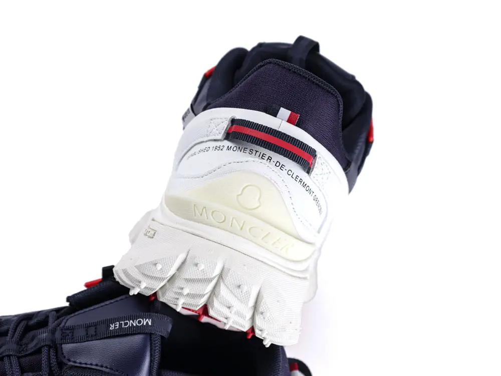 White rubber sneaker sole with red and blue fabric accents on the back.