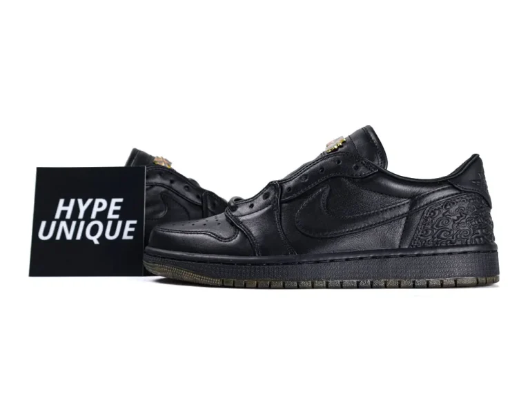 Black leather sneakers with intricate patterns, featuring a low-cut design and rubber soles.