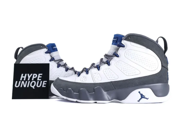 White and gray sneakers with blue accents, leather material, rubber sole visible.