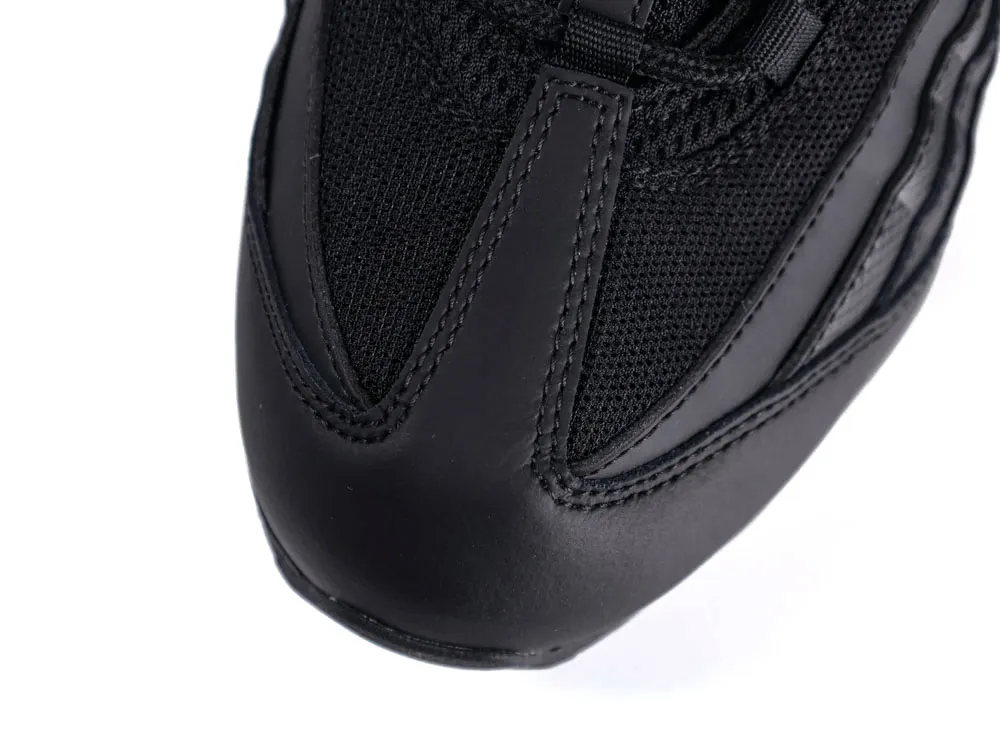 Close-up of a black leather and mesh sneaker's toe area, featuring detailed stitching.
