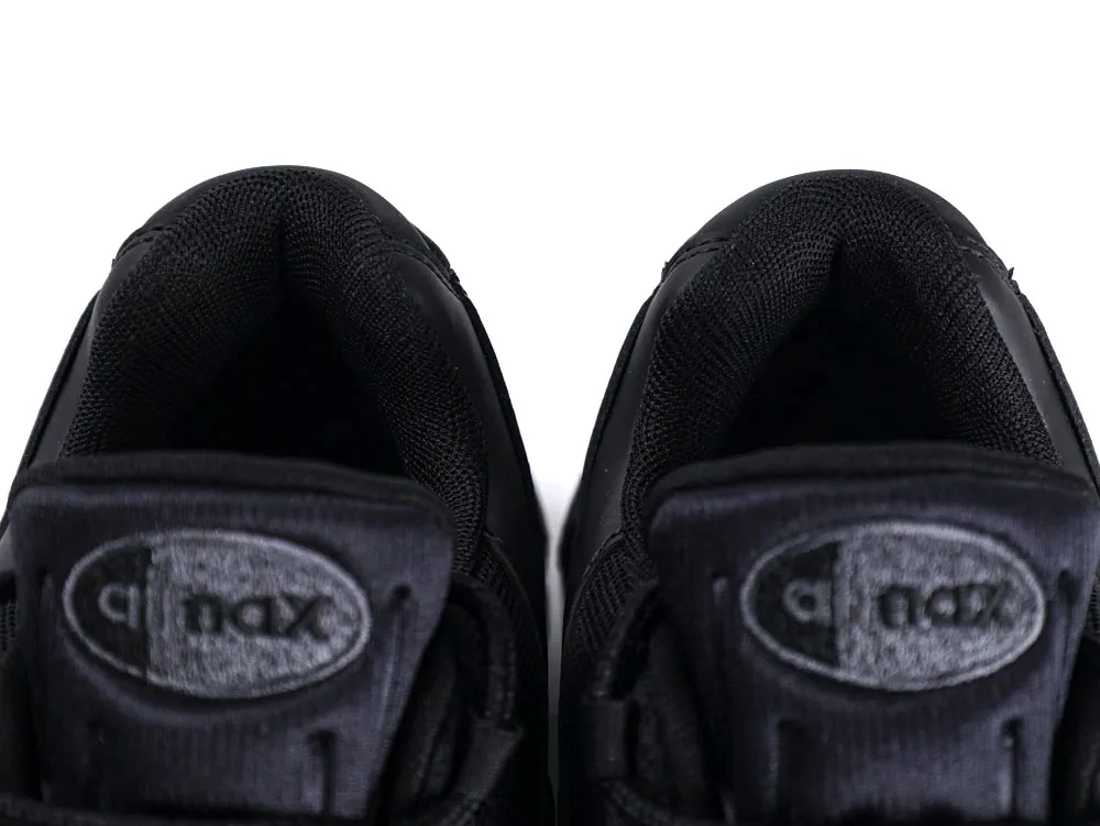 Black sneakers with mesh fabric, close-up of tongue and collar area.