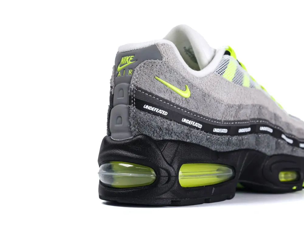 Gray suede sneaker with neon accents, black sole, and visible air unit.