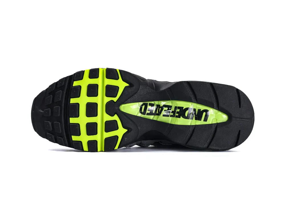Black and neon green rubber sneaker sole with grid-like pattern and logo.
