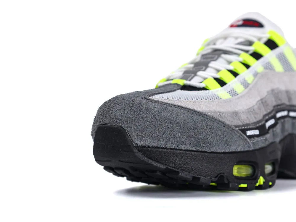 Gray suede sneaker with neon yellow accents and mesh upper, close-up view.