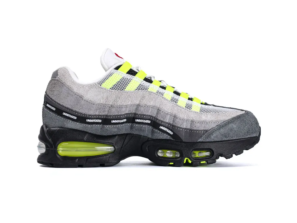 Gray and neon green sneaker with suede and mesh materials, black sole.