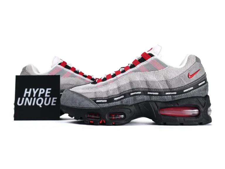 Gray and red sneakers with suede and mesh upper, black rubber sole.