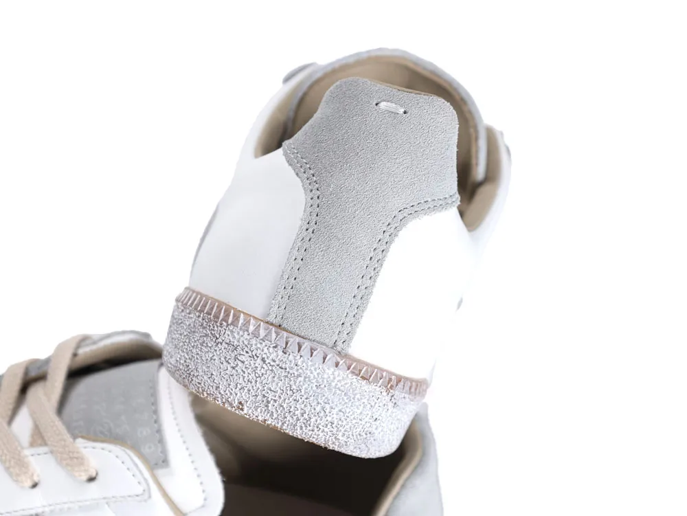 Gray suede sneaker heel with white leather upper and textured white rubber sole.