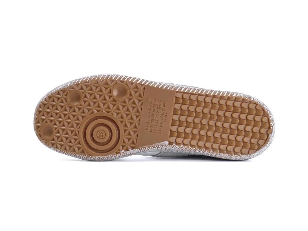Brown rubber shoe sole with silver glitter accents, showing textured grip pattern.