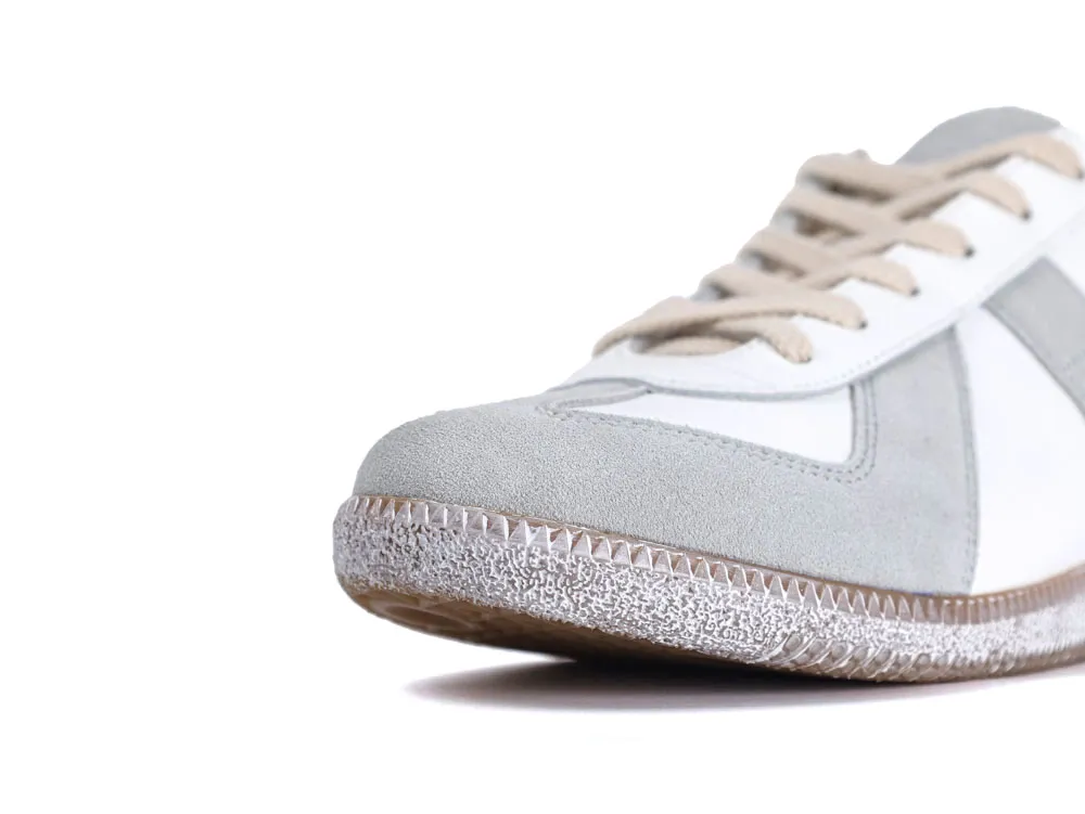 Gray suede and white leather sneaker with beige laces, textured rubber sole.