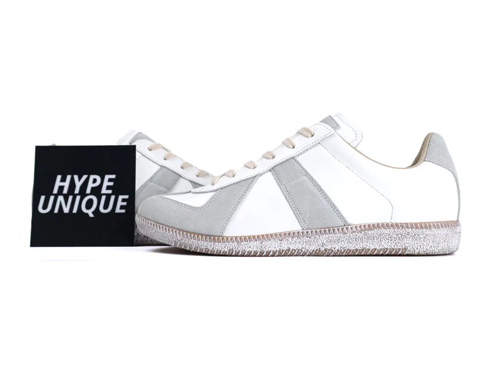 White leather and grey suede sneakers with textured rubber sole and beige laces.