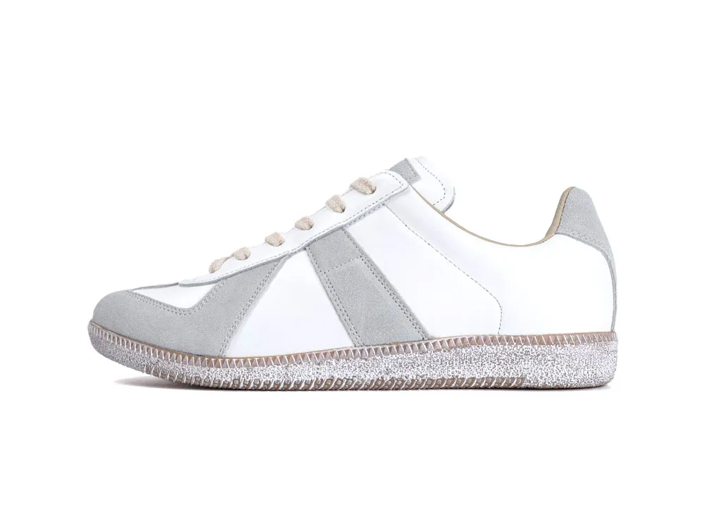 White and gray sneaker with suede accents and a textured rubber sole.