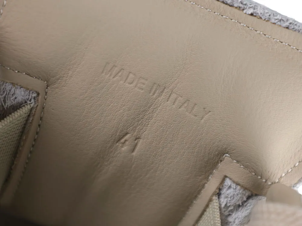 Brown leather interior with "Made in Italy" embossed on a shoe part.