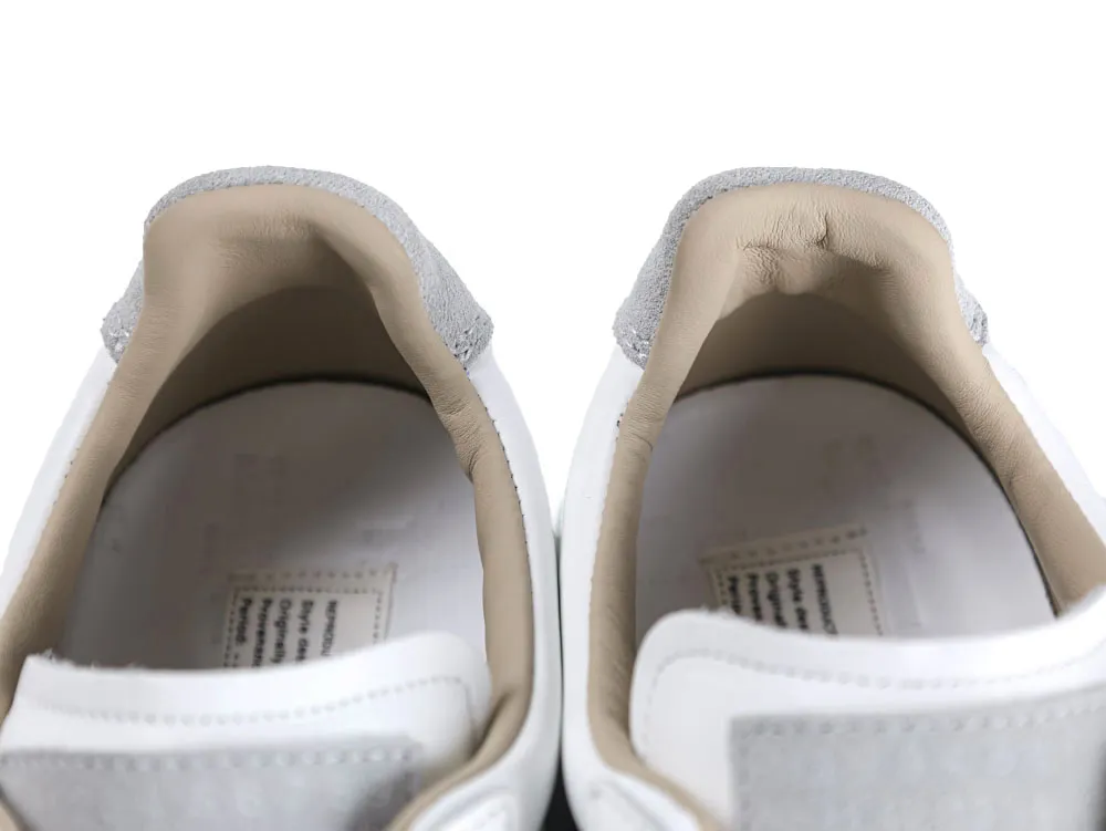 Gray suede and tan leather interiors of white sneakers.