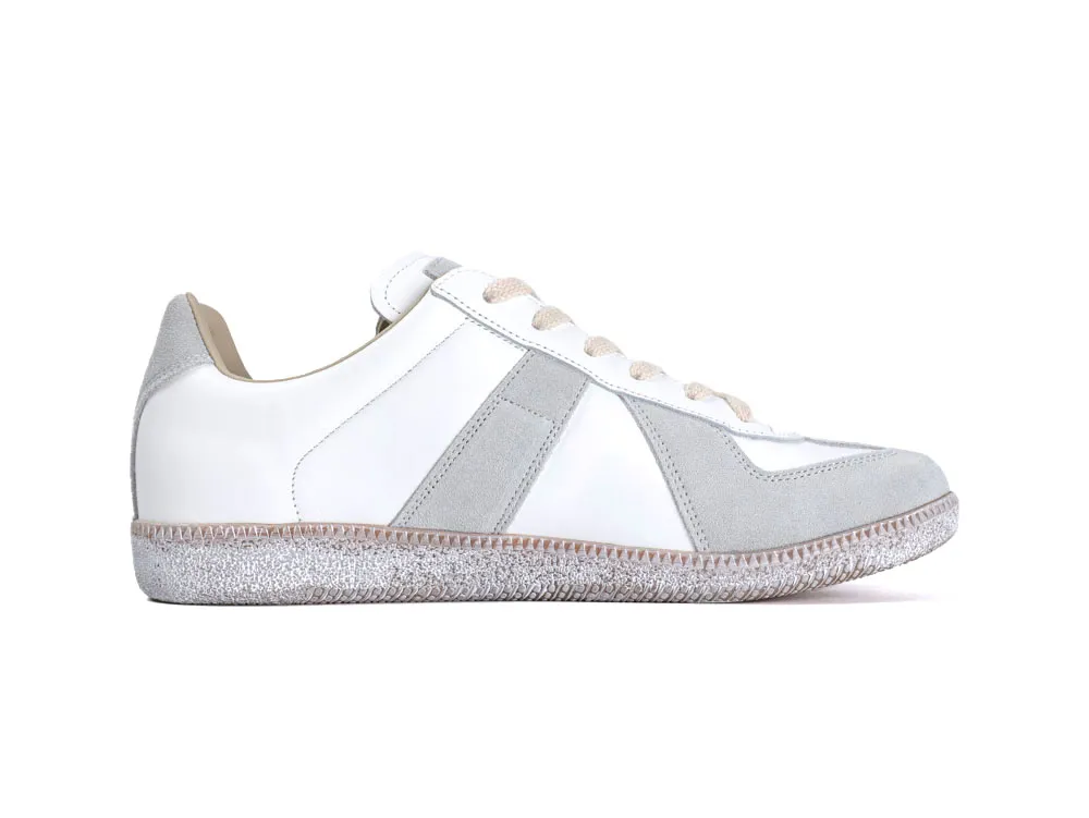White and grey sneaker with suede and leather materials, textured rubber sole.