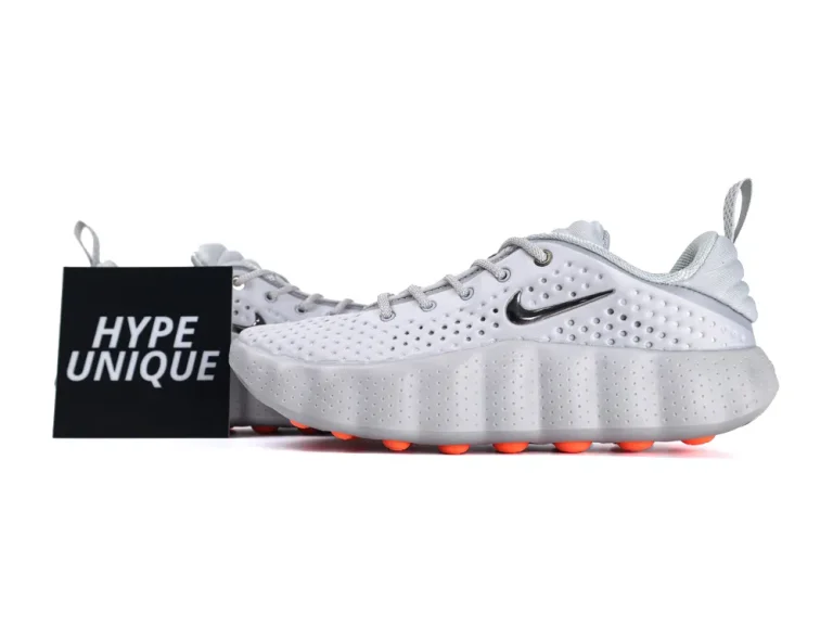 White sneakers with a perforated upper, rubber sole, and orange accents.