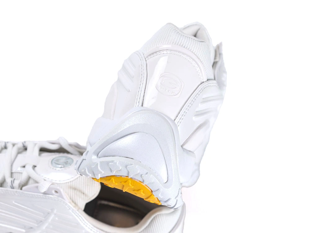 Side profile of sleek all-white sneakers showcasing wavy synthetic overlays and visible Air unit.