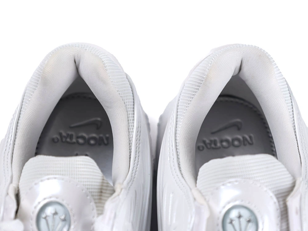 Side profile of sleek all-white sneakers showcasing wavy synthetic overlays and visible Air unit.