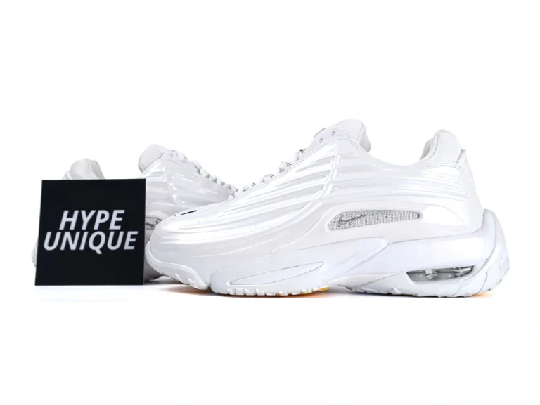 Side profile of sleek all-white sneakers showcasing wavy synthetic overlays and visible Air unit.