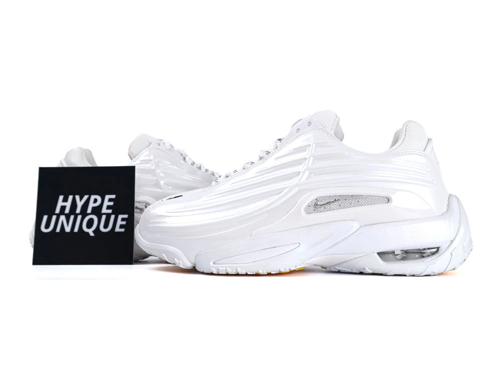 Side profile of sleek all-white sneakers showcasing wavy synthetic overlays and visible Air unit.