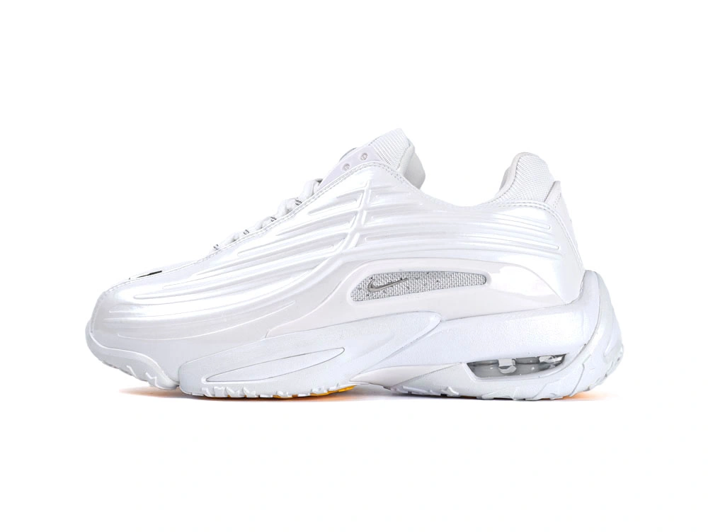 Side profile of sleek all-white sneakers showcasing wavy synthetic overlays and visible Air unit.