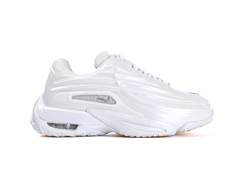 Side profile of sleek all-white sneakers showcasing wavy synthetic overlays and visible Air unit.