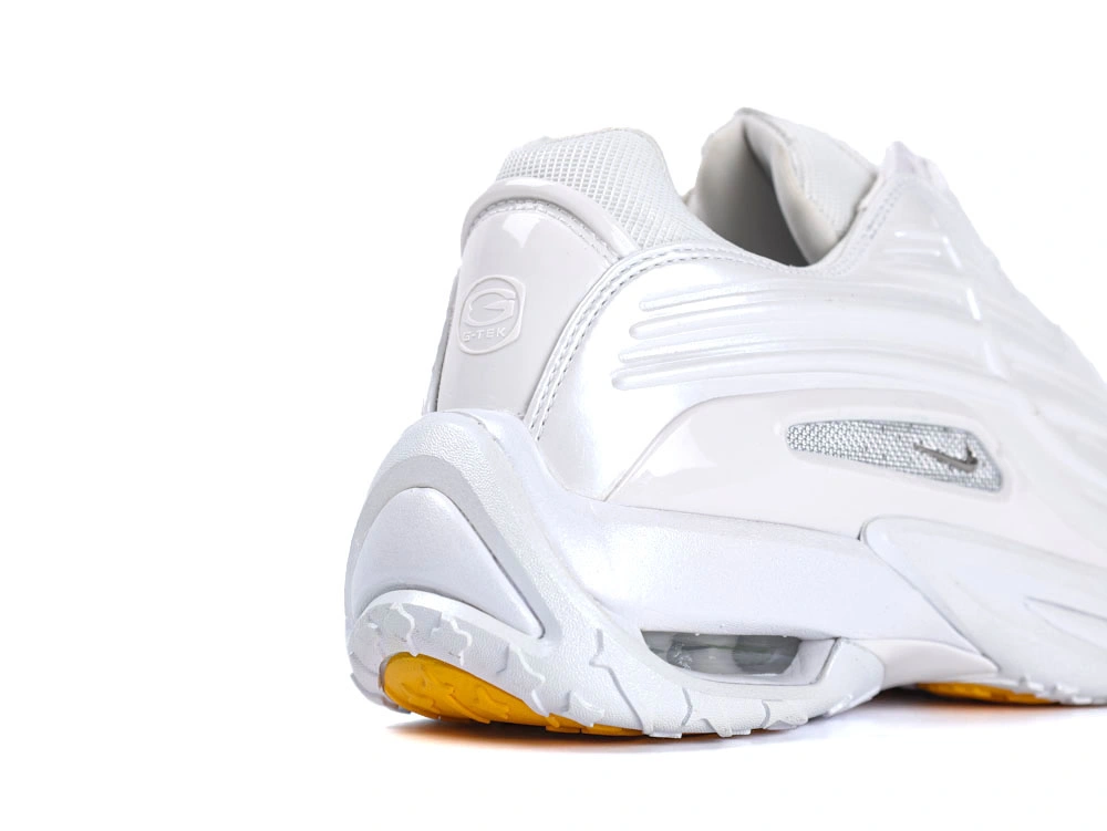 Side profile of sleek all-white sneakers showcasing wavy synthetic overlays and visible Air unit.