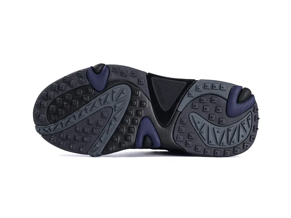 Black and navy rubber sneaker sole with textured grip pattern and geometric designs.