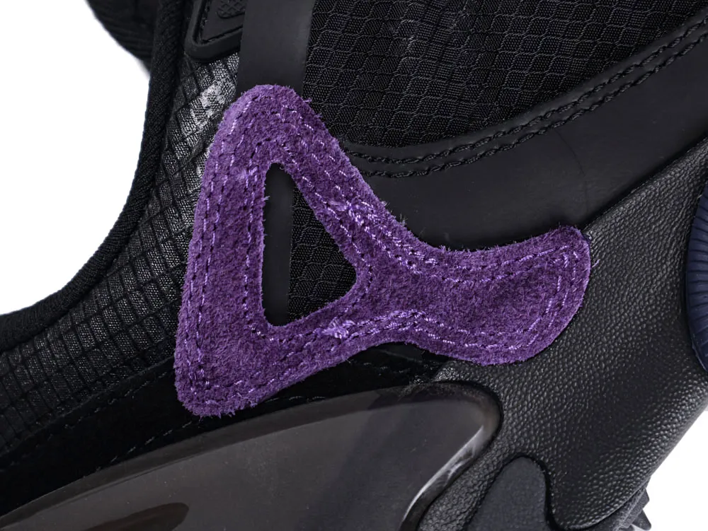 Black mesh shoe with a purple suede accent on the side.