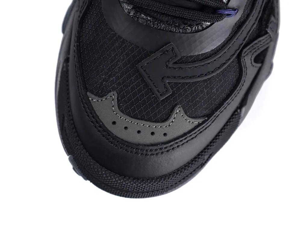 Black leather and mesh sneaker toe detail with intricate stitching and textured design.