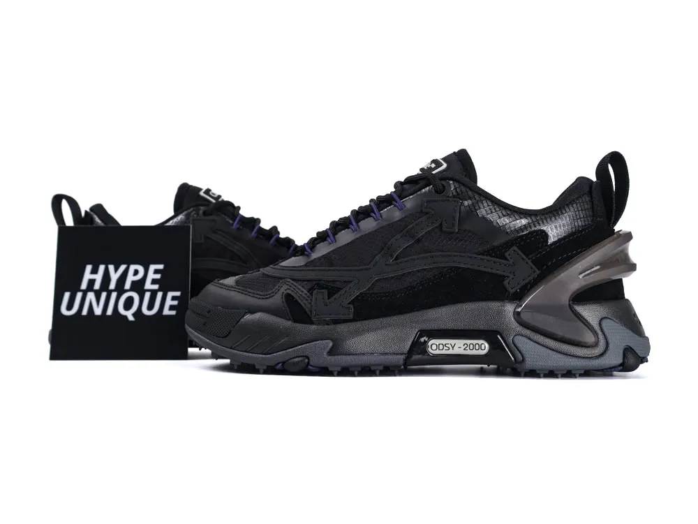 Black sneakers with suede and mesh materials, featuring a chunky sole and detailed design.