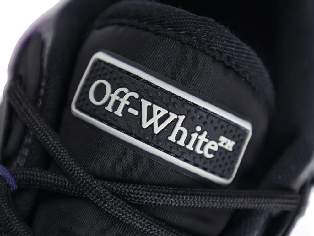 Black fabric shoe tongue with textured black rubber "Off-White" label.