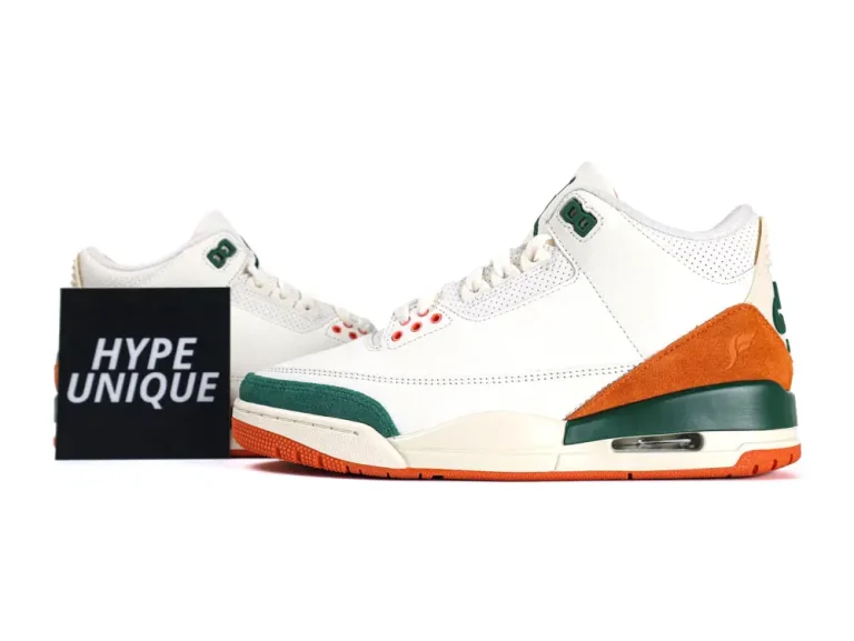 White leather sneakers with green and orange suede accents, featuring perforated detailing.
