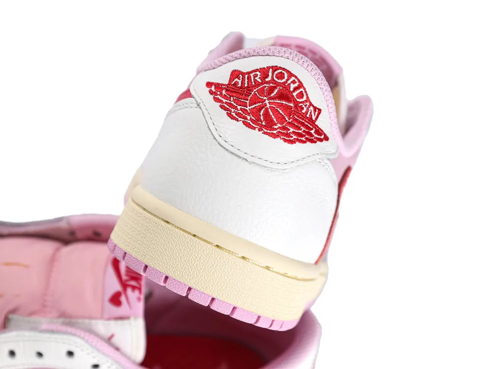 White leather sneaker with red embroidery, pink accents, and a cream sole.