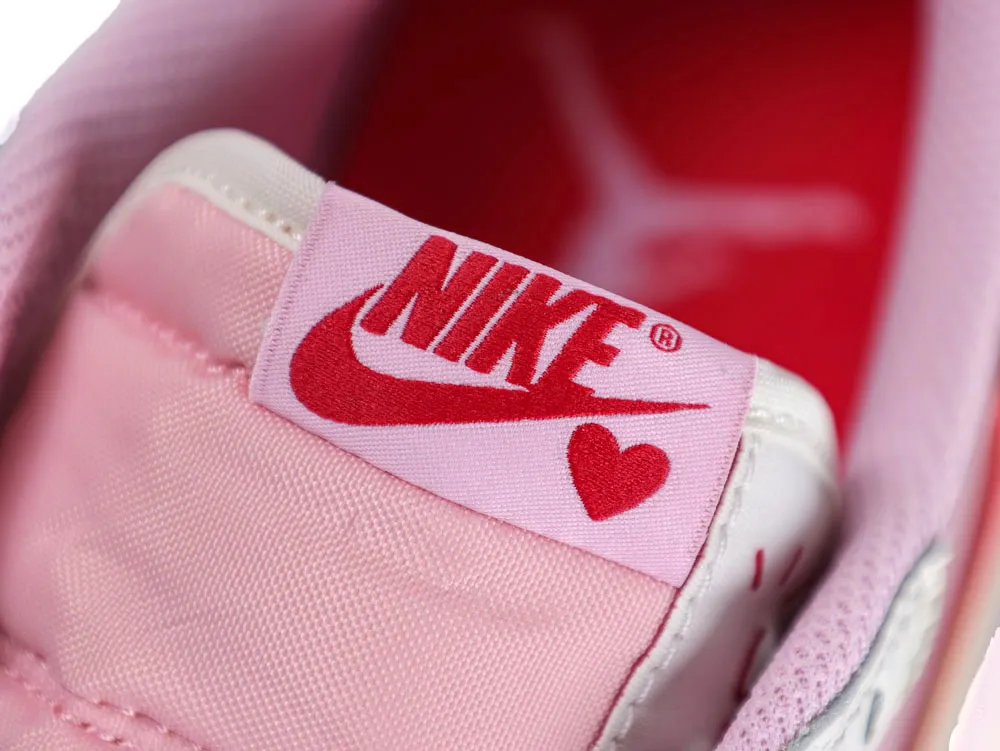 Close-up of a pink fabric shoe tongue with red logo and heart design.