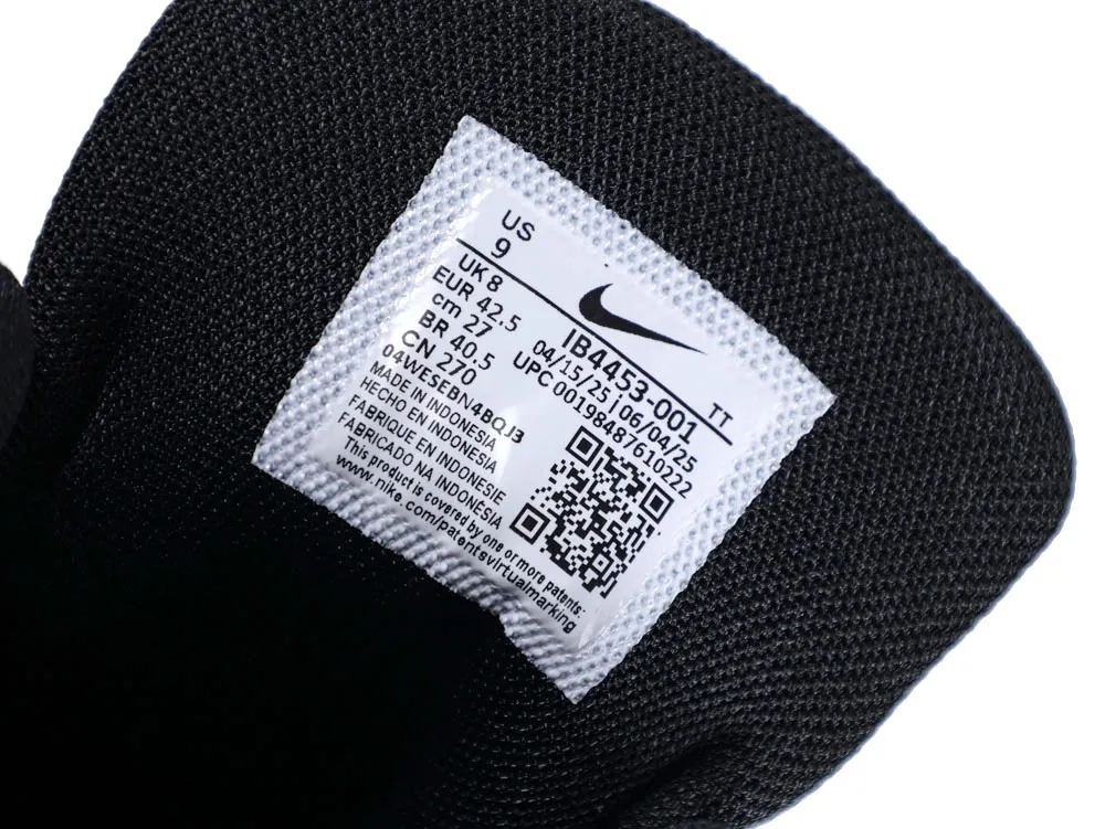 Black fabric shoe interior with a white label, displaying size and manufacturing details.