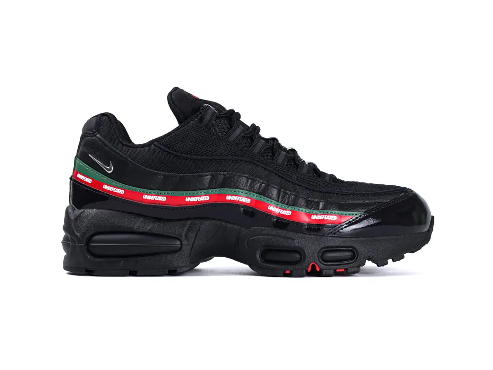 Black sneaker with synthetic material, red and green accents, and rubber sole.