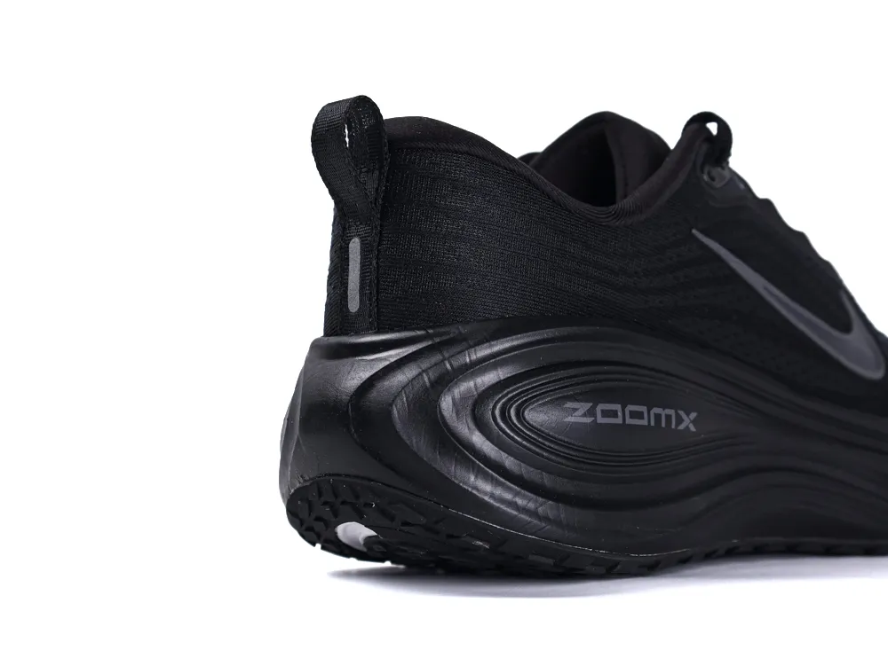Black sneaker with textured sole, made from synthetic material, featuring ZoomX branding.
