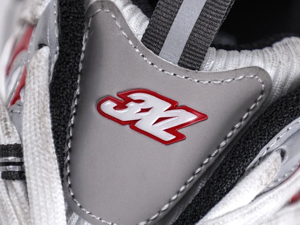 Close-up of a gray, fabric sneaker tongue with red logo detailing.